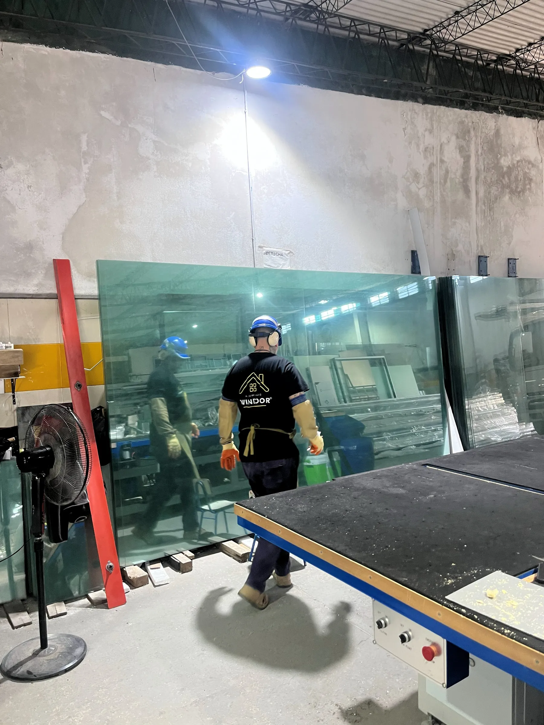 Operario de Windoor manipulando placas de vidrio para DVH en el taller